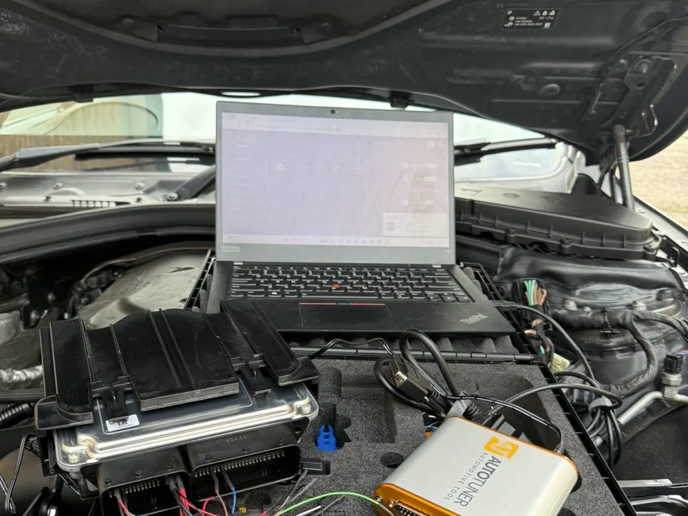 ECU being remapped on a laptop in a customer's engine bay